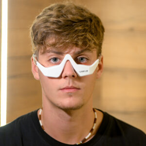 Hombre recibiendo un tratamiento de fototerapia para el contorno de ojos con las gafas de Hissys Technologies